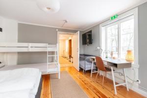 a bedroom with a bunk bed and a desk at Segerstadsby Gårdshotell AB in Vålberg