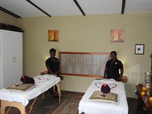 two men sitting in a room with two beds at Votadini Country Cottages in Magaliesburg