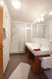 y baño blanco con lavabo y ducha. en Appartements Fliana Mathon/Ischgl, en Ischgl