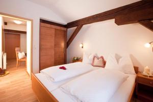 sypialnia z dużym białym łóżkiem z białymi poduszkami w obiekcie Appartements Fliana Mathon/Ischgl w mieście Ischgl