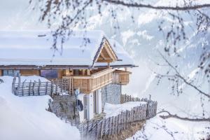 a log cabin in the snow with a fence at Chalet Henne- Hochgruberhof in Selva dei Molini