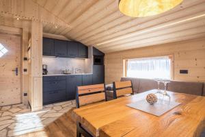 uma cozinha e sala de jantar com uma mesa de madeira em Chalet Henne- Hochgruberhof em Selva dei Molini
