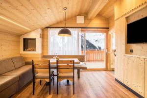 a dining room with a table and a couch at Chalet Henne- Hochgruberhof in Selva dei Molini