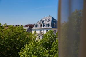 una grande casa bianca con tetto blu di Maingau Hotel a Francoforte sul Meno