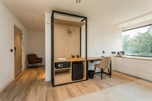 a kitchen with a counter and a table and chairs at Hotel de Rousch in Heerlen