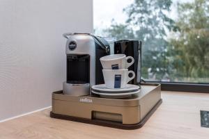 a coffee machine sitting on a table with cups at Hotel de Rousch in Heerlen