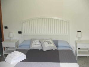 a bedroom with a bed with two tables and two pillows at La casetta di Sofia in Moneglia