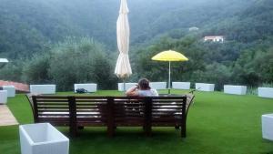 モネーリアにあるLa casetta di Sofiaの傘下のベンチに座る女