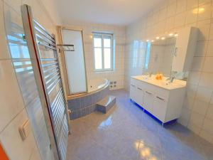 ein Badezimmer mit einer Badewanne, einem Waschbecken und einem Spiegel in der Unterkunft Apartments SteelCity in Linz
