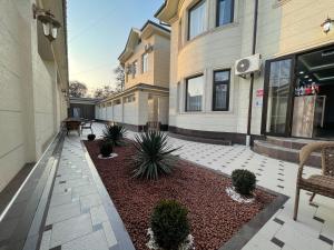 塔什干Shosh Palace的建筑前种有植物的庭院