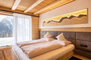 a bed sitting in a room with a window at Chalets Reisnock - Hochgruberhof in Selva dei Molini
