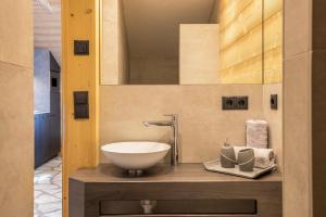 un bagno con un lavandino e uno specchio di Chalets Reisnock - Hochgruberhof a Selva dei Molini