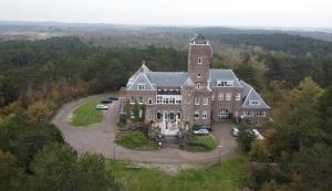 una vista aérea de una casa grande con coches aparcados en Landgoed Huize Glory en Bergen aan Zee