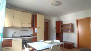 a kitchen with wooden cabinets and a white table at Residenza Cleopatra 4 in Falconara Marittima
