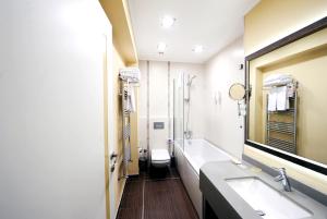 a bathroom with a sink and a toilet and a mirror at Grand Nora Hotel in Ankara