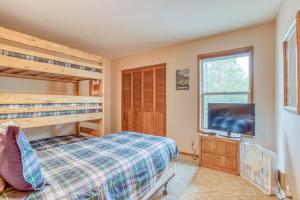 a bedroom with bunk beds and a flat screen tv at Red Cedar Lane 60 - Meredith Lodging in Sunriver