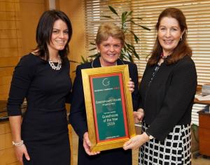 two women are holding a framed award plaque at Greenmount House in Dingle