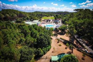 an aerial view of a resort with a pool and trees at LE COTTAGE VUE LAC-2 vélos-Village Vacances Nature de 70ha! avec piscines et animations in Léon