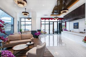 a lobby with couches and tables in a building at Wesley Hotel in Bukit Mertajam