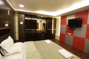 1 dormitorio con 1 cama y TV en la pared en Hotel Metro Palace, en Bombay