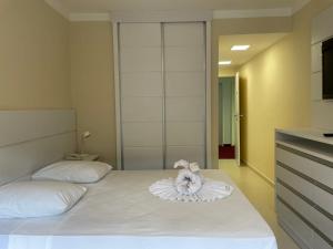 a bedroom with a bed with a towel on it at Hotel Cavalinho Branco - Aptos 241 e 317 in Águas de Lindóia