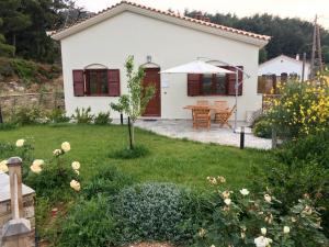 a white house with a garden and a table at Aria Monte Villas in Raches