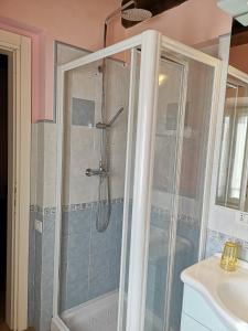 una ducha con una puerta de cristal junto a un lavabo en Agriturismo Vecchio Gelso, en Ortezzano