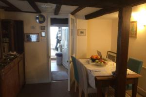 a kitchen with a table with a bowl of fruit on it at Cathedral View Cottage, Canterbury in Kent