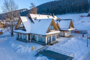 dom pokryty śniegiem w śniegu w obiekcie Apartamenty Pod Stokiem Nosal Zakopane w Zakopanem