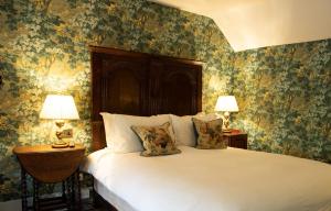 1 dormitorio con 1 cama grande y papel pintado con motivos florales en Ockenden Manor Hotel & Spa en Cuckfield