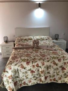 ein Bett mit einer geblümten Bettdecke mit Schleife in der Unterkunft Casa Rural El Horno Masca in Buenavista del Norte