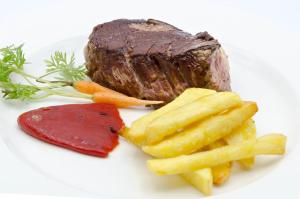 ein Steak und Pommes auf einem weißen Teller in der Unterkunft Arha Reserva del Saja in Renedo