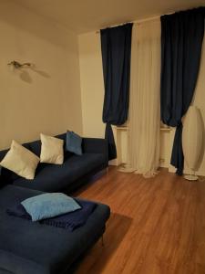un soggiorno con divano blu e tende di Leoncino Apartment 2 a Verona