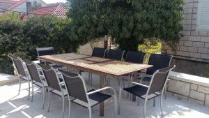 a wooden table and chairs on a patio at Apartment Kika *** in Pučišća +21 photos