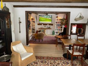 a living room with a television and a table and chairs at Hotel Knurrhahn in Glücksburg