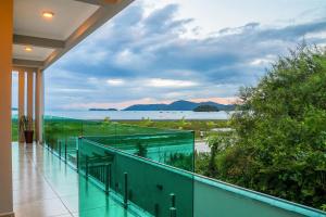 an empty balcony with a view of the water at Calamar Flats - Frente à Praia do Jabaquara in Paraty