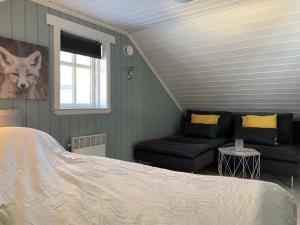 a bedroom with a bed and a couch and a window at Lemonsjøen-Jotunheimen-Besseggen in Stuttgongfossen