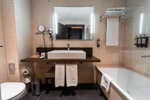 a bathroom with a sink and a tub and a toilet at La Laguna Gran Hotel in Las Lagunas