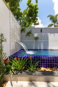 a fountain in a backyard with a blue at Calamar Flats Paraty in Paraty
