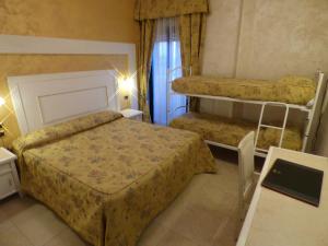 a small bedroom with two beds and a table at Hotel Diplomat Palace in Rimini