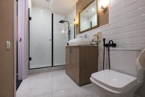 uma casa de banho com um WC, um lavatório e um chuveiro em Iren river side apartments em Tbilisi