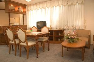 a living room with a dining room table and chairs at Chiangmai Ratanakosin Hotel in Chiang Mai
