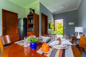 a dining room with a table with plates on it at Calamar Flats - Frente à Praia do Jabaquara in Paraty +52 photos
