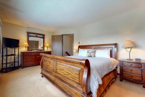 a bedroom with a large wooden bed and a television at Darwin E in Jackson