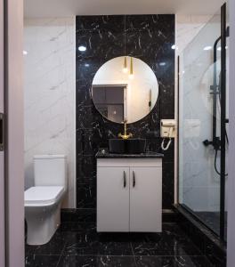 uma casa de banho com um WC, um lavatório e um espelho. em Iren river side apartments em Tbilisi