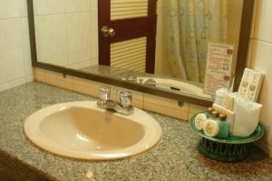 a bathroom sink in front of a bathroom mirror at Chiangmai Ratanakosin Hotel in Chiang Mai +22 photos