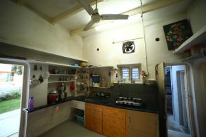 a kitchen with a black counter top and a refrigerator at Gurukrupa Bunglow in Dwarka