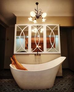 a white bath tub with a persons feet in it at Bakenhof Winelands Lodge in Paarl