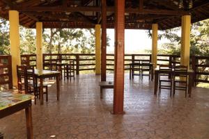 a restaurant with wooden tables and chairs in a room at Pousada Campestre Estância São Domingos in Serra Negra