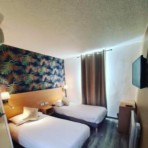 Säng eller sängar i ett rum på Hotel Les Beaux Soleils